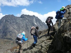 Hikers trekking along a rocky trail in the Rwenzori Mountains, Uganda